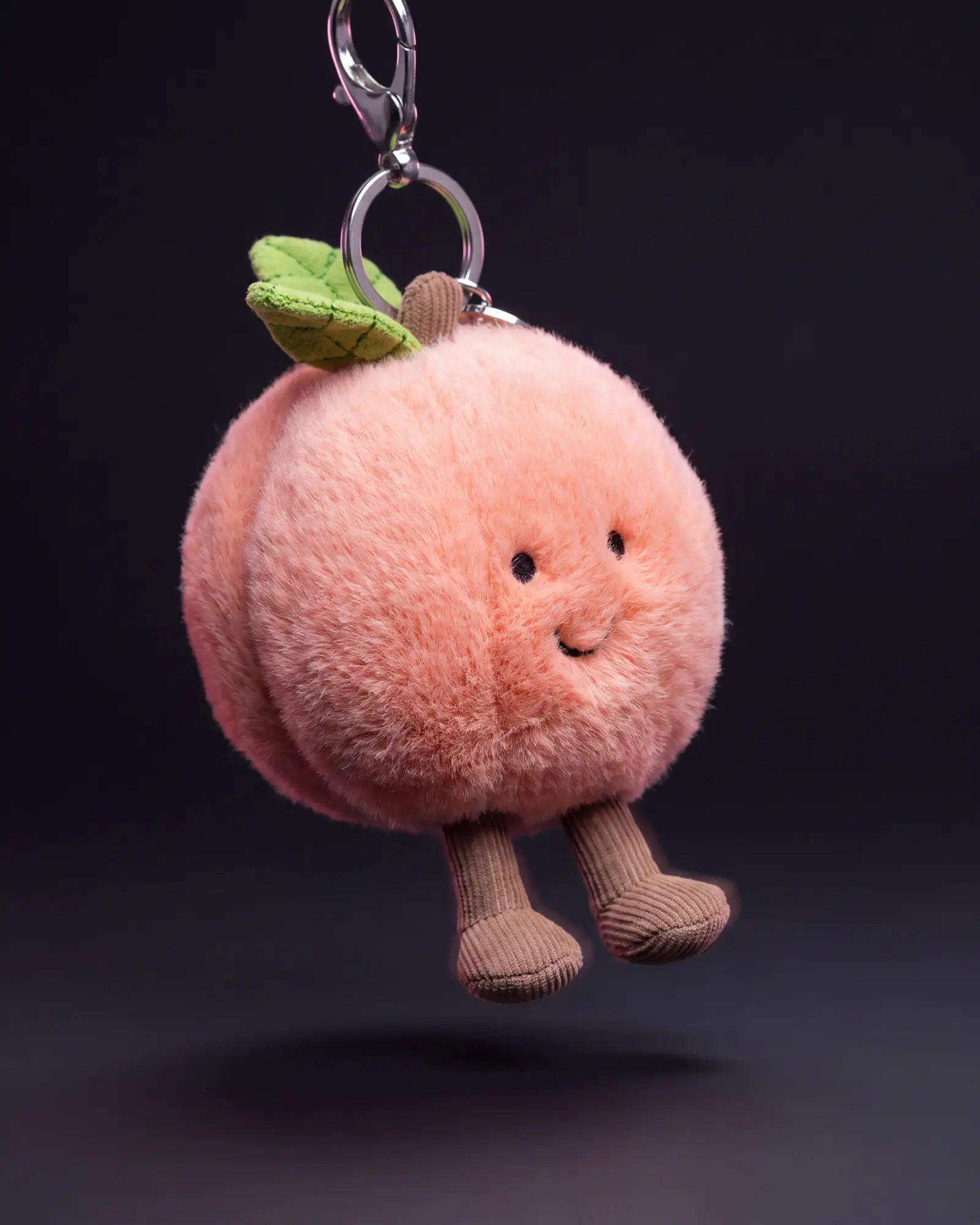 Amuseables Peach Bag Charm, 어두운 스튜디오 배경.