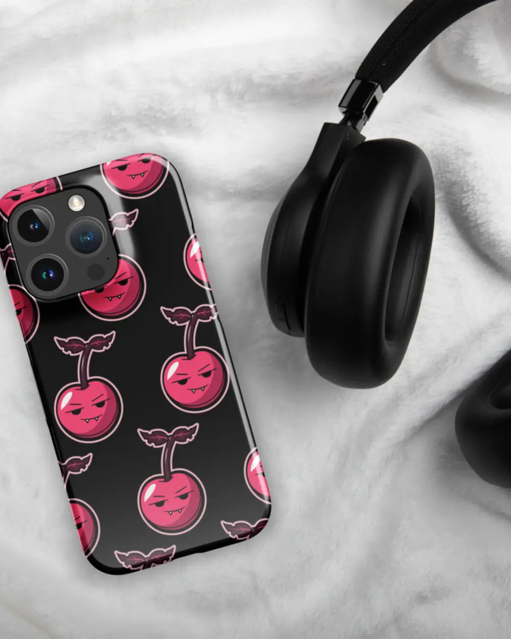 헤드폰 옆에 앞면이 위로 놓인 Cherry Case.