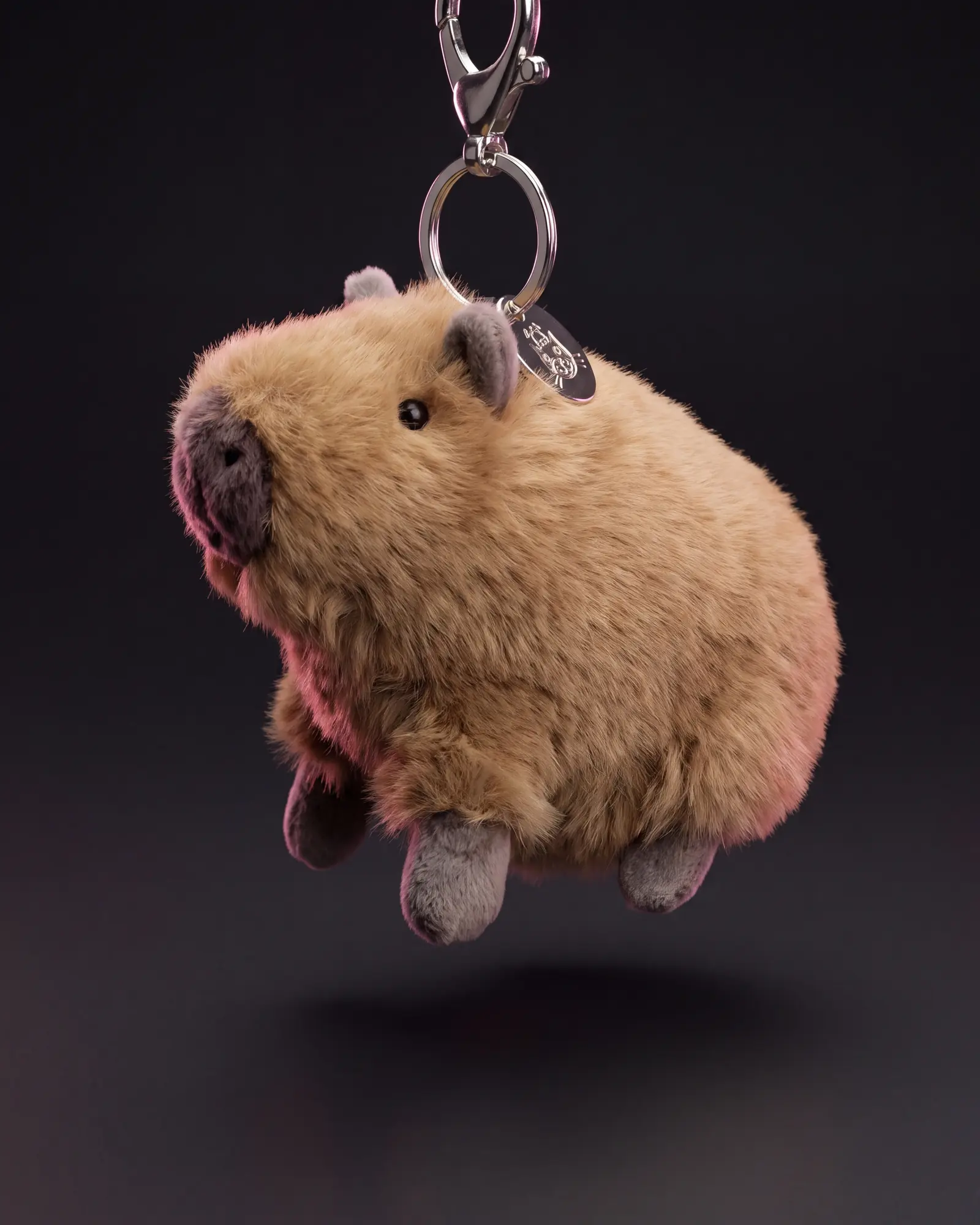 Clyde Capybara Bag Charm, 어두운 스튜디오 배경.